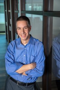 Photo of Adam Schrager in front of glass