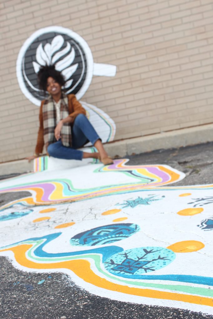 Women against a brick wall mural